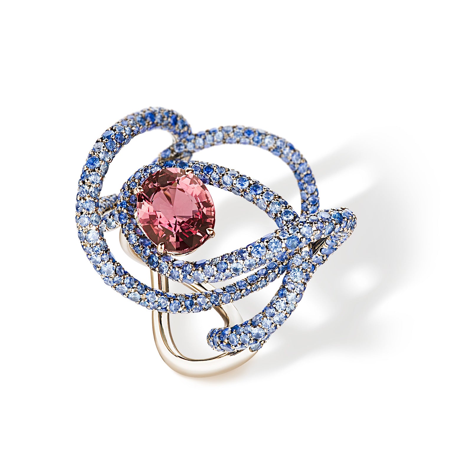 Ring with natural reddish-pink oval sapphire surrounded by rings 